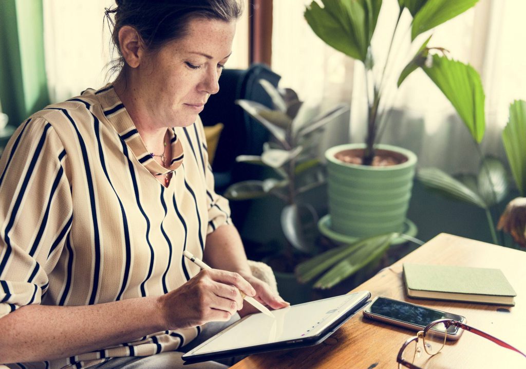 Caucasian woman writing to do list on tablet