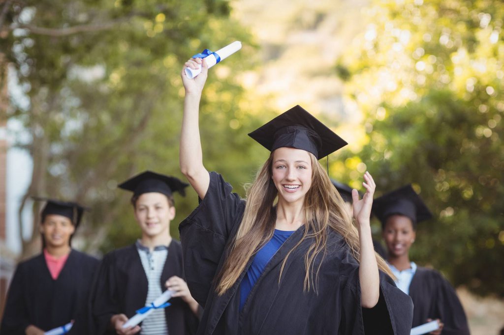 Graduate school kids standing with degree scroll in campus